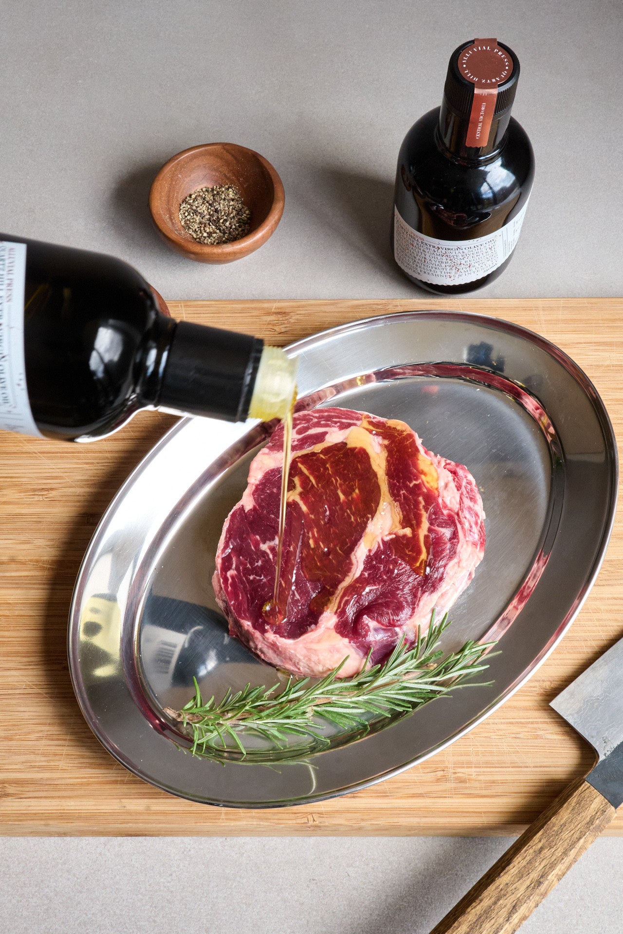 Raw steak coated in high-polyphenol Australian extra virgin olive oil ready for grilling.