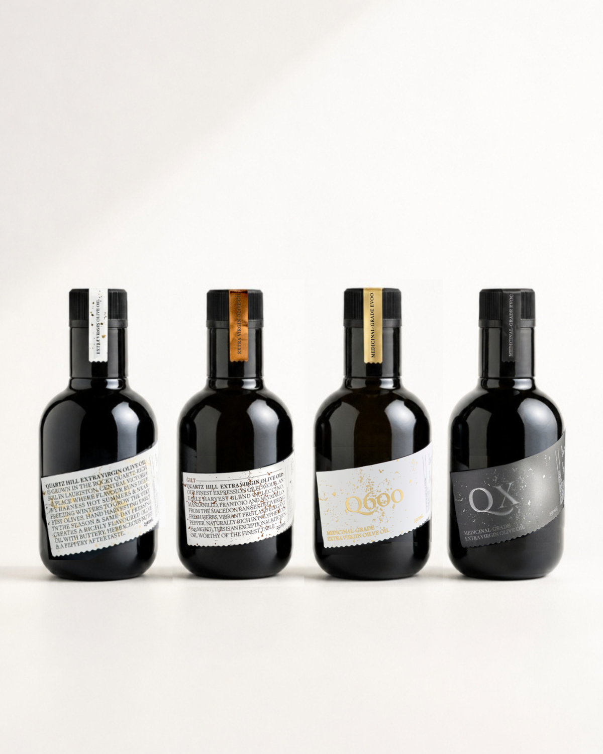 A premium 4-pack lineup of Quartz Hill high-polyphenol extra virgin olive oils from the Macedon Ranges, featuring the Estate Oil, GILT, Q600, and QX 250ml dark glass bottles against a clean white backdrop.