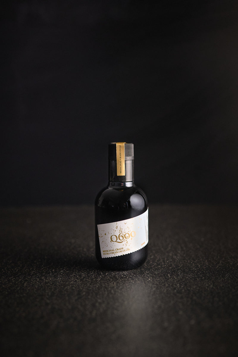 High polyphenol early harvest olive oil bottle from Australia in a dark glass bottle with harvest date on black bench.