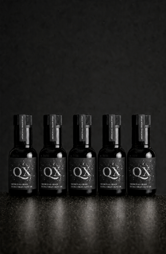 Five 100ml black bottles of QX Medicinal-Grade Extra Virgin Olive Oil arranged in a row against a dark background for a 30-day challenge